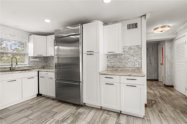2576 Sunset Dr, New Smyrna Beach, FL 32168 - kitchen featuring built in refrigerator, a sink, tasteful backsplash, white cabinetry, and recessed lighting