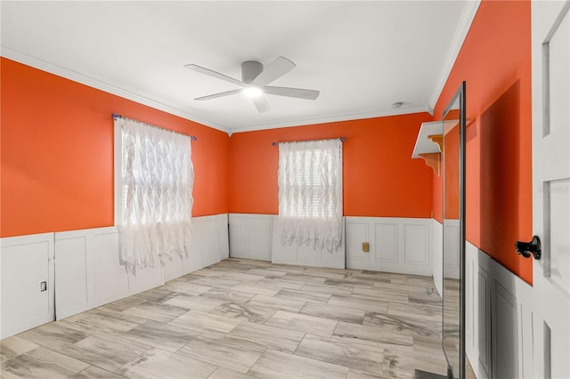 2576 Sunset Dr, New Smyrna Beach, FL 32168 - empty room featuring a ceiling fan, ornamental molding, a wainscoted wall, and a decorative wall