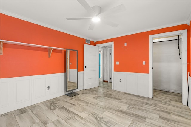 2576 Sunset Dr, New Smyrna Beach, FL 32168 - unfurnished bedroom with crown molding, a wainscoted wall, ceiling fan, a closet, and a decorative wall