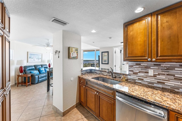 2625 S Atlantic Ave Unit 18Nw, Daytona Beach, FL 32118 - kitchen with dishwasher, a sink, backsplash, brown cabinets, and stone counters