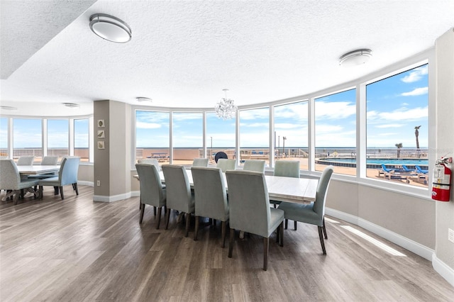 2625 S Atlantic Ave Unit 18Nw, Daytona Beach, FL 32118 - dining space featuring a textured ceiling, wood finished floors, baseboards, and a chandelier