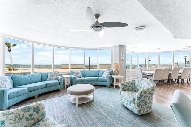 2625 S Atlantic Ave Unit 18Nw, Daytona Beach, FL 32118 - living room featuring a textured ceiling, wood finished floors, ceiling fan, and a water view