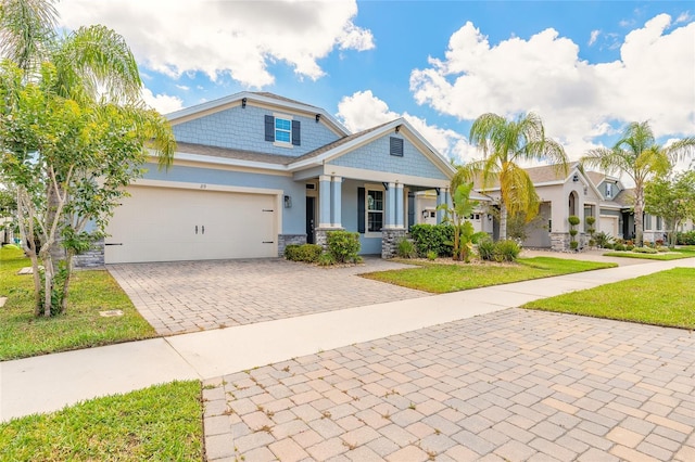 219 Venetian Palms Blvd, New Smyrna Beach, FL 32168 - craftsman inspired home with stone siding, stucco siding, decorative driveway, an attached garage, and a front lawn