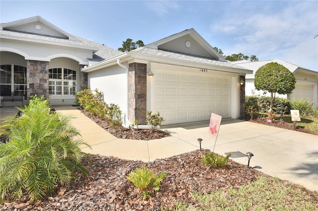 1442 Carlow Cir, Ormond Beach, FL 32174 - view of front of home featuring stone siding, driveway, stucco siding, an attached garage, and a shingled roof