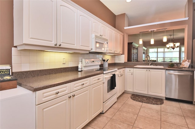 1442 Carlow Cir, Ormond Beach, FL 32174 - kitchen featuring white appliances, dark countertops, a sink, and white cabinetry
