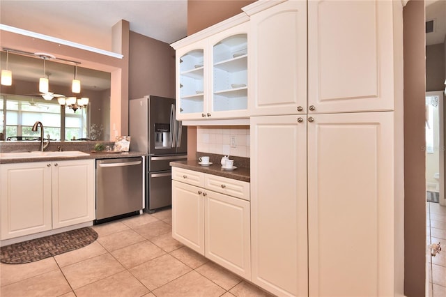 1442 Carlow Cir, Ormond Beach, FL 32174 - kitchen with stainless steel appliances, dark countertops, light tile patterned flooring, glass insert cabinets, and tasteful backsplash