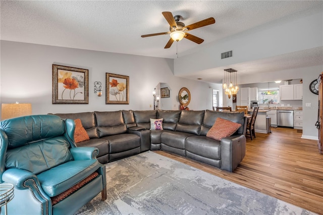 1205 Bond St, Edgewater, FL 32132 - living area with lofted ceiling, a ceiling fan, light wood-type flooring, a textured ceiling, and a chandelier