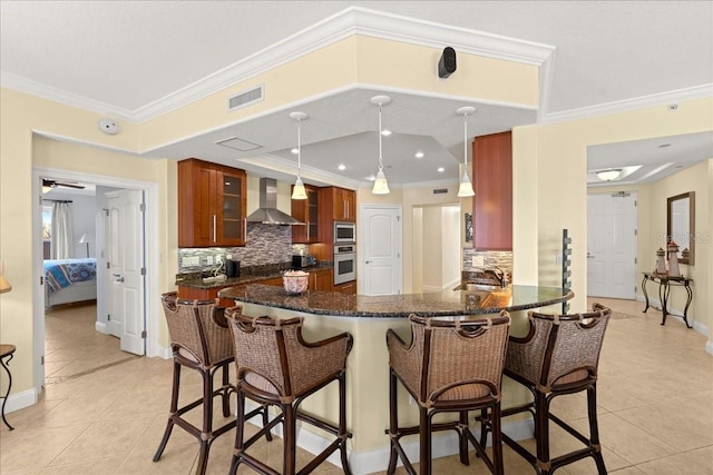 3245 S Atlantic Ave Unit 208, Daytona Beach, FL 32118 - kitchen with appliances with stainless steel finishes, wall chimney exhaust hood, light tile patterned floors, backsplash, and ornamental molding