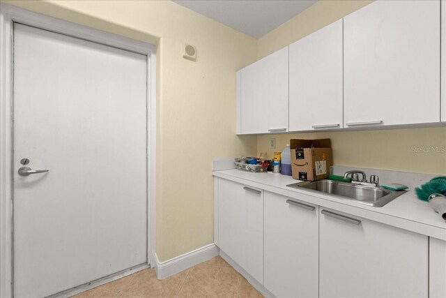 3245 S Atlantic Ave Unit 208, Daytona Beach, FL 32118 - kitchen featuring a sink, light countertops, baseboards, white cabinets, and light tile patterned flooring