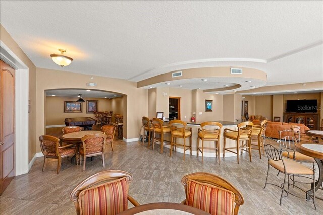 3245 S Atlantic Ave Unit 208, Daytona Beach, FL 32118 - dining room featuring baseboards and a textured ceiling