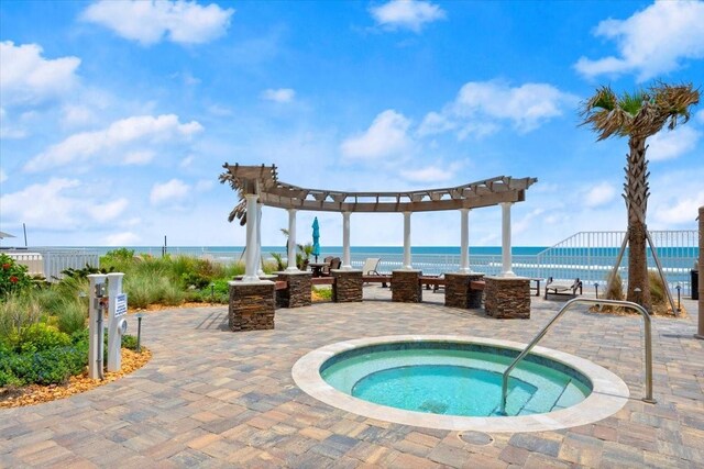 3245 S Atlantic Ave Unit 208, Daytona Beach, FL 32118 - view of swimming pool with a pergola, a hot tub, a patio area, and a water view