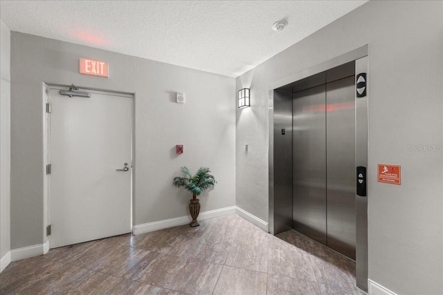 3245 S Atlantic Ave Unit 208, Daytona Beach, FL 32118 - corridor with elevator, a textured ceiling, and baseboards