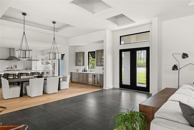 1624 Turnbull Crossings Dr, New Smyrna Beach, FL 32168 - kitchen with light tile patterned floors, wall chimney exhaust hood, open floor plan, wine cooler, and healthy amount of natural light