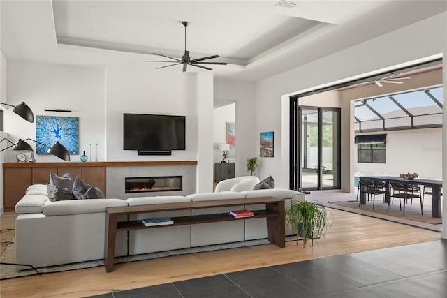 1624 Turnbull Crossings Dr, New Smyrna Beach, FL 32168 - living room with a tray ceiling, tile patterned flooring, and a ceiling fan