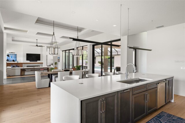 1624 Turnbull Crossings Dr, New Smyrna Beach, FL 32168 - kitchen with a sink, open floor plan, light wood finished floors, a ceiling fan, and a kitchen island with sink