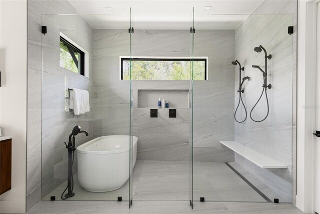 1624 Turnbull Crossings Dr, New Smyrna Beach, FL 32168 - bathroom featuring a freestanding tub, walk in shower, tile walls, and vanity