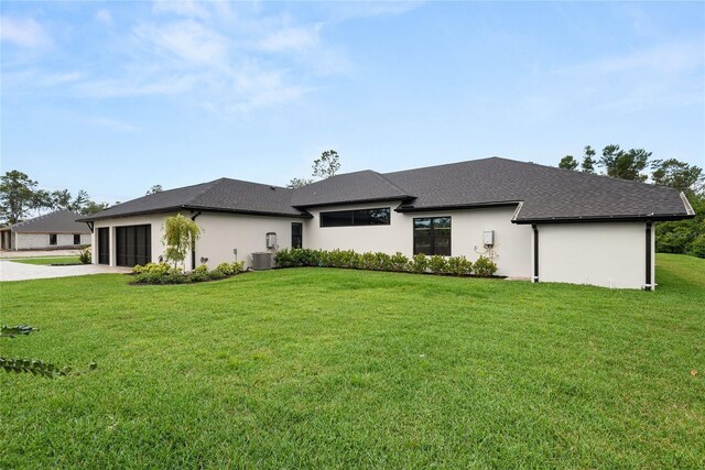 1624 Turnbull Crossings Dr, New Smyrna Beach, FL 32168 - rear view of property featuring an attached garage, a yard, concrete driveway, and stucco siding