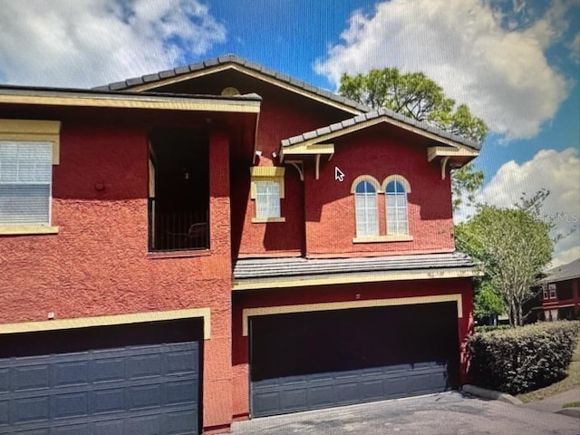 240 Villa Di Este Ter Unit 212, Lake Mary, FL 32746 - view of front facade featuring an attached garage, stucco siding, and driveway