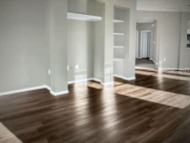 240 Villa Di Este Ter Unit 212, Lake Mary, FL 32746 - unfurnished living room with wood finished floors, built in shelves, and baseboards