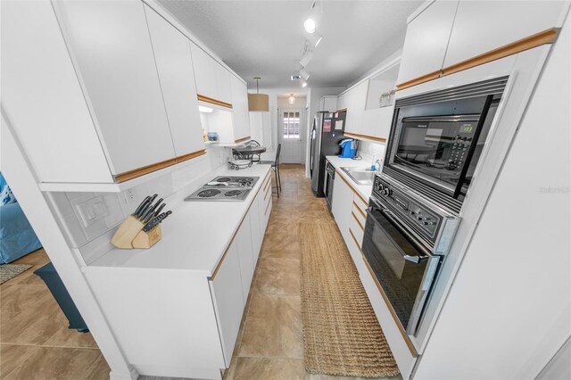2961 Oceans Trce, Daytona Beach Shores, FL 32118 - kitchen featuring black appliances, white cabinets, light countertops, and light tile patterned floors