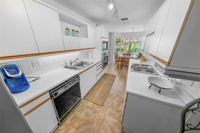 2961 Oceans Trce, Daytona Beach Shores, FL 32118 - kitchen featuring black appliances, a sink, rail lighting, light countertops, and a textured ceiling