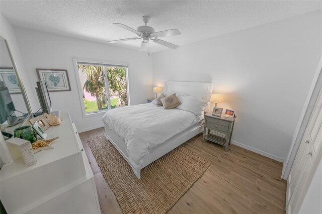 2961 Oceans Trce, Daytona Beach Shores, FL 32118 - bedroom with a textured ceiling, light wood-type flooring, baseboards, and a ceiling fan