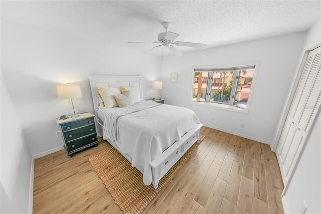 2961 Oceans Trce, Daytona Beach Shores, FL 32118 - bedroom with light wood-type flooring, baseboards, a textured ceiling, and a ceiling fan