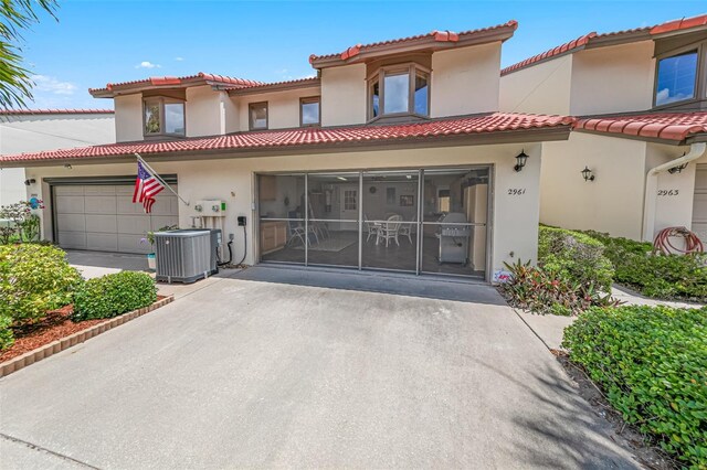 2961 Oceans Trce, Daytona Beach Shores, FL 32118 - mediterranean / spanish-style house with stucco siding, central AC unit, a tile roof, and an attached garage