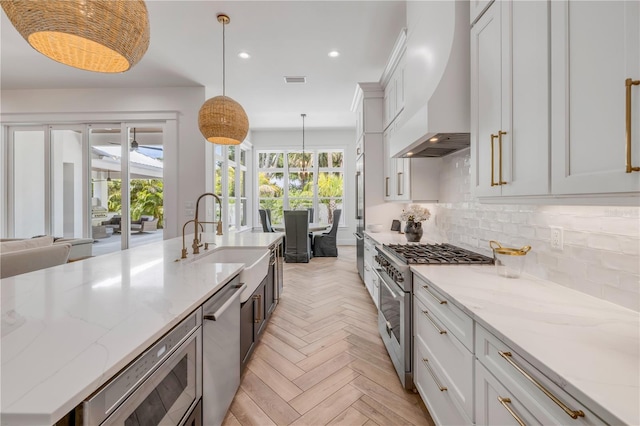 102 Inlet Shores Dr, New Smyrna Beach, FL 32168 - kitchen featuring high quality appliances, a sink, custom exhaust hood, decorative backsplash, and recessed lighting