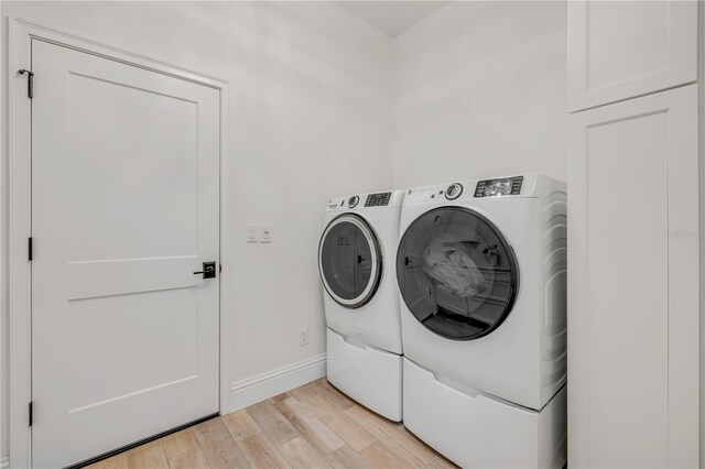 102 Inlet Shores Dr, New Smyrna Beach, FL 32168 - washroom with washer and clothes dryer, light wood-style floors, and baseboards