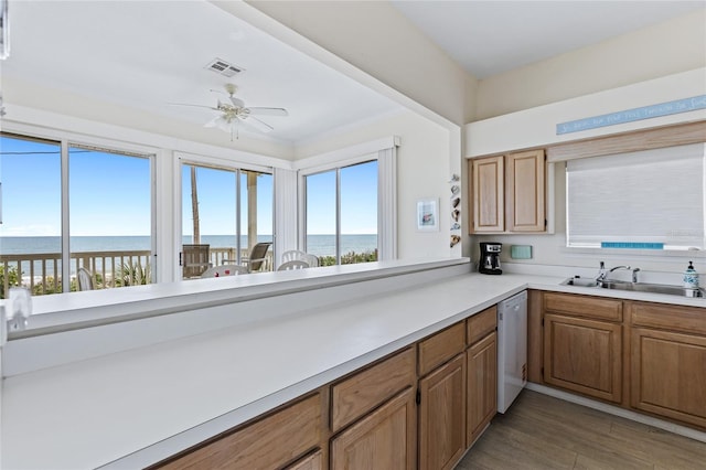 6320 S Atlantic Ave, New Smyrna Beach, FL 32169 - kitchen featuring white dishwasher, a sink, a water view, and ceiling fan