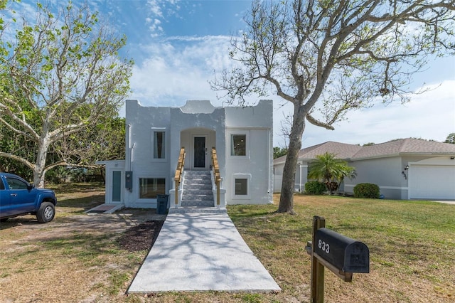 833 E 12th Ave, New Smyrna Beach, FL 32169 - view of front of property with stucco siding and a front lawn