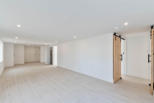 833 E 12th Ave, New Smyrna Beach, FL 32169 - spare room featuring a barn door, recessed lighting, light wood-type flooring, baseboards, and a smoke detector
