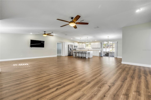 1144 Corbin Park Rd, New Smyrna Beach, FL 32168 - unfurnished living room with a ceiling fan, recessed lighting, dark wood finished floors, baseboards, and vaulted ceiling