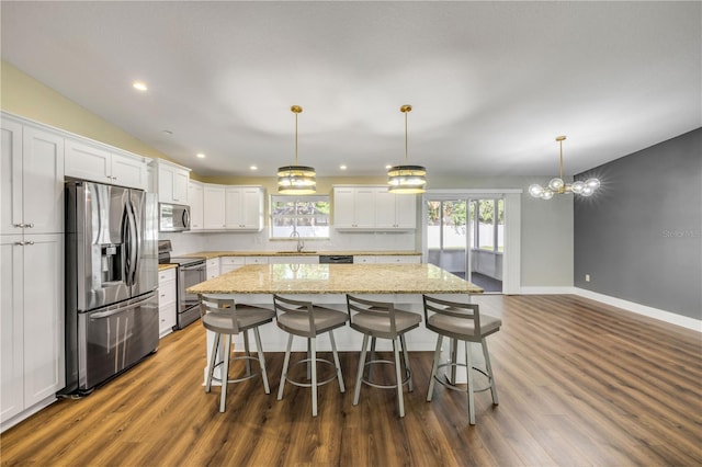 1144 Corbin Park Rd, New Smyrna Beach, FL 32168 - kitchen featuring appliances with stainless steel finishes, a center island, dark wood-style flooring, white cabinetry, and recessed lighting