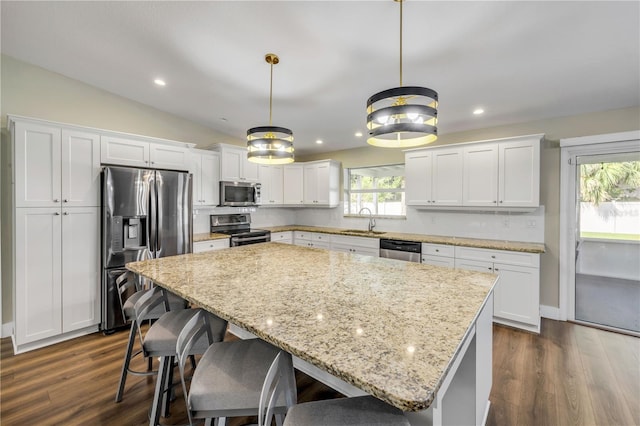 1144 Corbin Park Rd, New Smyrna Beach, FL 32168 - kitchen featuring stainless steel appliances, a sink, a center island, white cabinetry, and dark wood-style flooring