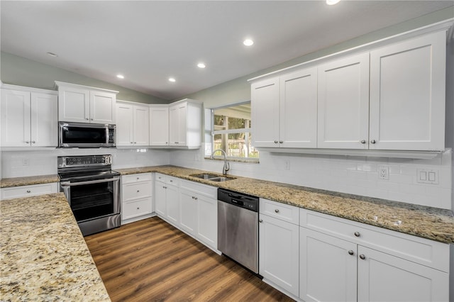 1144 Corbin Park Rd, New Smyrna Beach, FL 32168 - kitchen featuring stainless steel appliances, a sink, lofted ceiling, white cabinetry, and backsplash