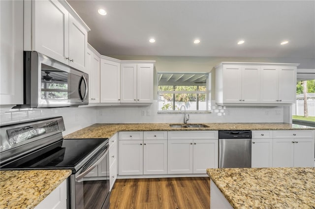 1144 Corbin Park Rd, New Smyrna Beach, FL 32168 - kitchen featuring stainless steel appliances, a sink, dark wood-style floors, white cabinets, and recessed lighting