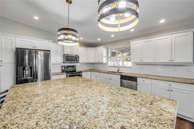 1144 Corbin Park Rd, New Smyrna Beach, FL 32168 - kitchen featuring stainless steel appliances, a sink, vaulted ceiling, white cabinets, and a spacious island