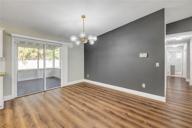 1144 Corbin Park Rd, New Smyrna Beach, FL 32168 - unfurnished room featuring wood finished floors, baseboards, and a chandelier