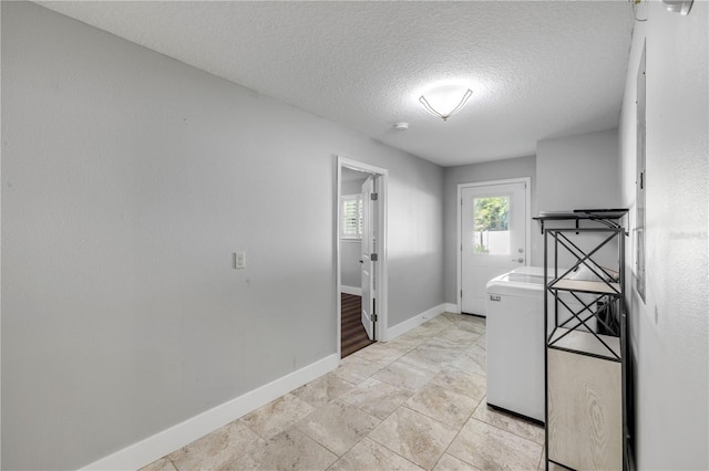 1144 Corbin Park Rd, New Smyrna Beach, FL 32168 - laundry room featuring a textured ceiling and baseboards