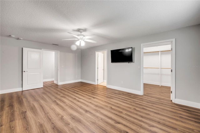 1144 Corbin Park Rd, New Smyrna Beach, FL 32168 - unfurnished bedroom featuring wood finished floors, baseboards, a spacious closet, and a textured ceiling