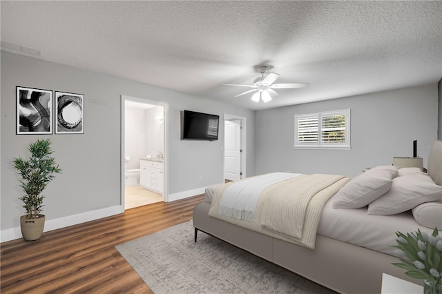 1144 Corbin Park Rd, New Smyrna Beach, FL 32168 - bedroom with wood finished floors, a textured ceiling, ensuite bath, and ceiling fan