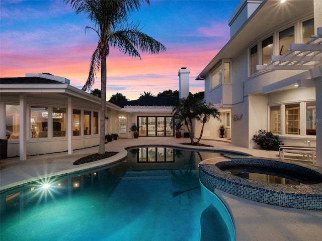 1215 Commodore Dr, New Smyrna Beach, FL 32168 - pool at dusk with a patio and a pool with connected hot tub