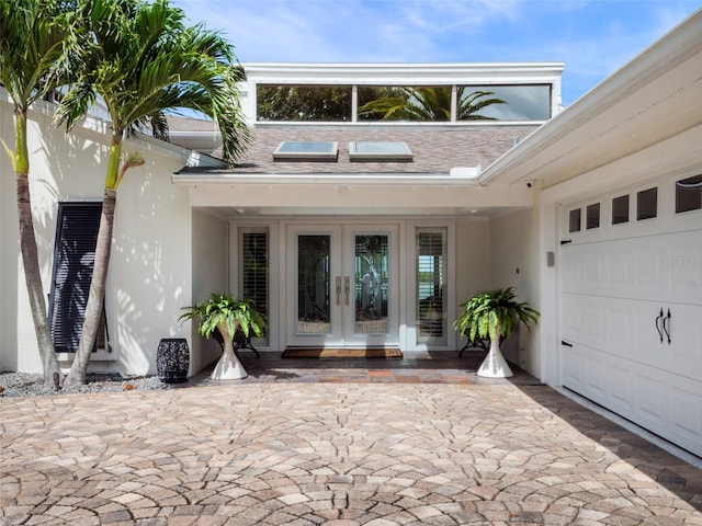 1215 Commodore Dr, New Smyrna Beach, FL 32168 - view of exterior entry featuring french doors, stucco siding, and a garage