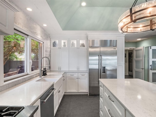 1215 Commodore Dr, New Smyrna Beach, FL 32168 - kitchen featuring appliances with stainless steel finishes, white cabinets, light stone counters, dark tile patterned flooring, and recessed lighting