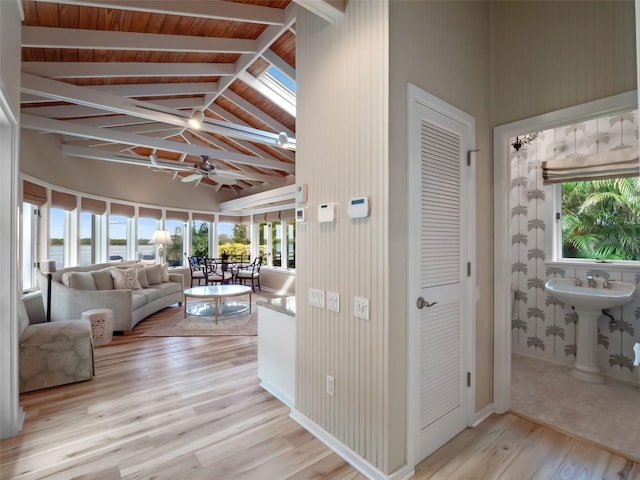 1215 Commodore Dr, New Smyrna Beach, FL 32168 - living room with light wood-type flooring, beam ceiling, ceiling fan, and high vaulted ceiling