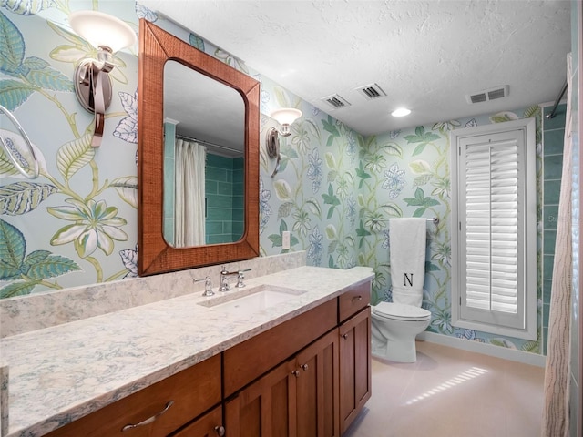 1215 Commodore Dr, New Smyrna Beach, FL 32168 - bathroom with vanity, wallpapered walls, a textured ceiling, and tile patterned floors
