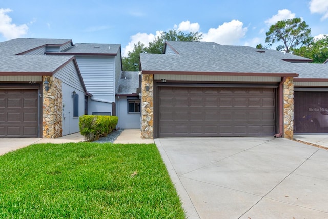 488 Shorewood Ln, New Smyrna Beach, FL 32168 - view of front of home with roof with shingles, stone siding, driveway, an attached garage, and a front lawn