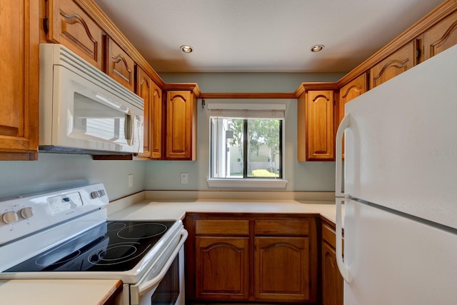 488 Shorewood Ln, New Smyrna Beach, FL 32168 - kitchen featuring white appliances, light countertops, brown cabinets, and recessed lighting